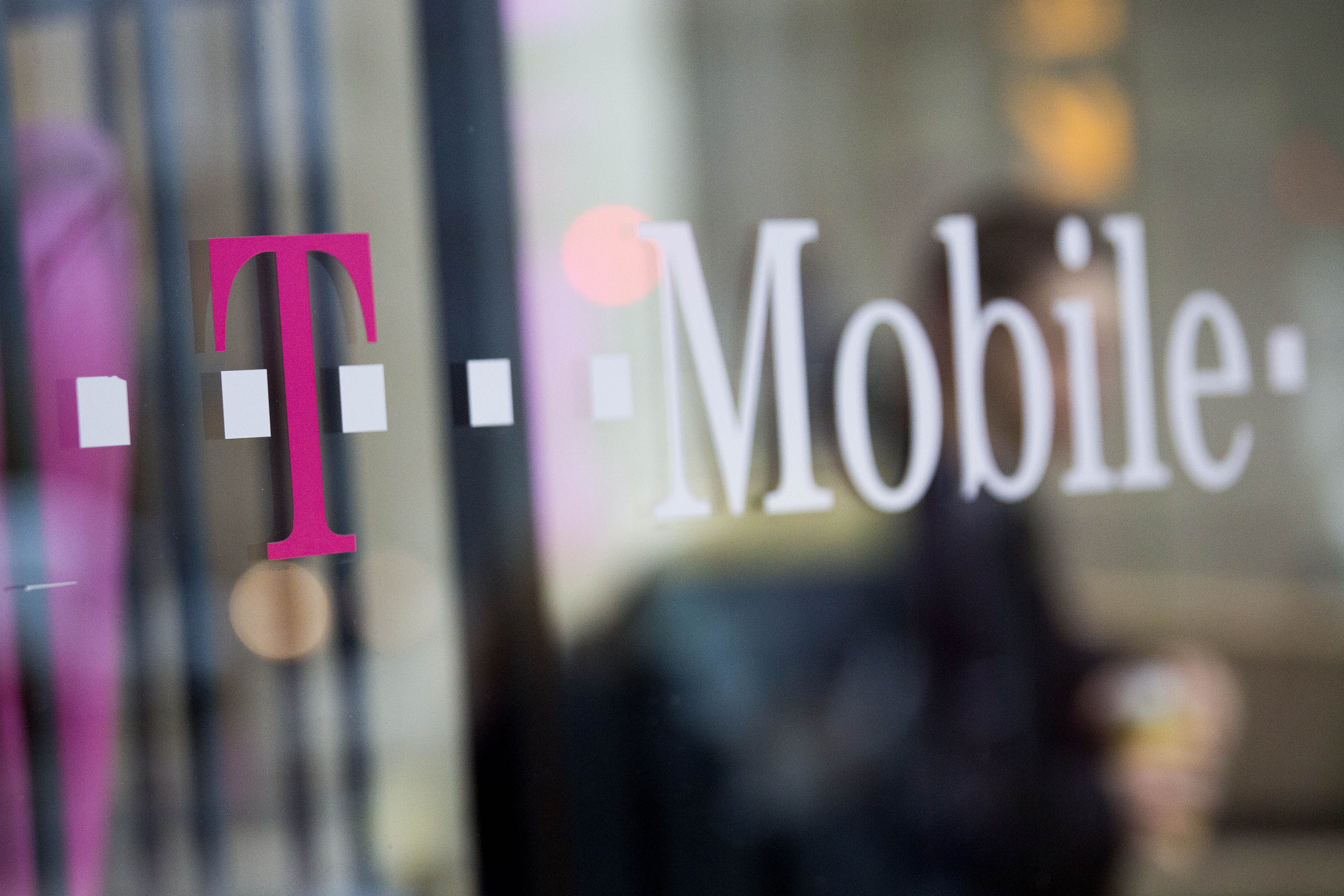 Bloomberg via Getty Images		T Mobile US Inc. signage is displayed in the window of a retail store in Washington D.C. on Oct. 23 2014