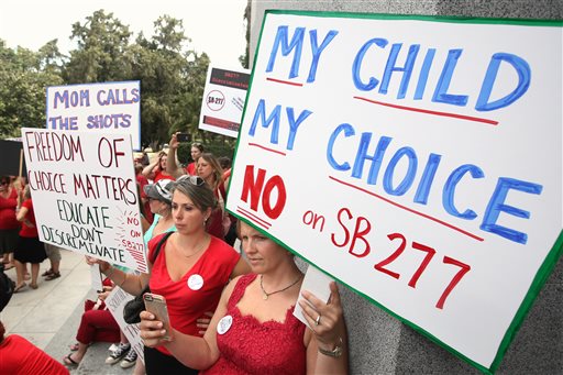 Karman Willmer left and Shelby Messenger protest against SB277 a measure requiring California schoolchildren to get vaccinated at a Capitol rally Tuesday