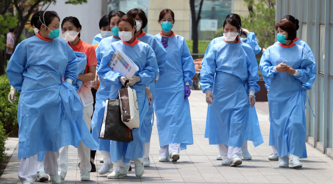 Medical staff walk in front of Konkuk University Medical Center which has been partially shut down due to MERS in eastern Seoul on Wednesday