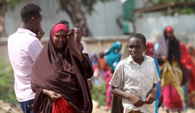 People react as they look at bodies at the scene of a car bomb attack in Hodan district in the capital Mogadishu