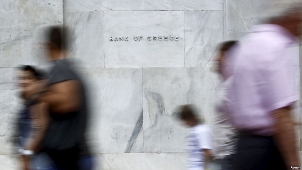 People walk past the Bank of Greece in Athens