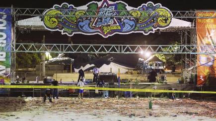 Police investigators inspect the stage area after an accidental explosion during a music concert at the Formosa Water Park in New Taipei City