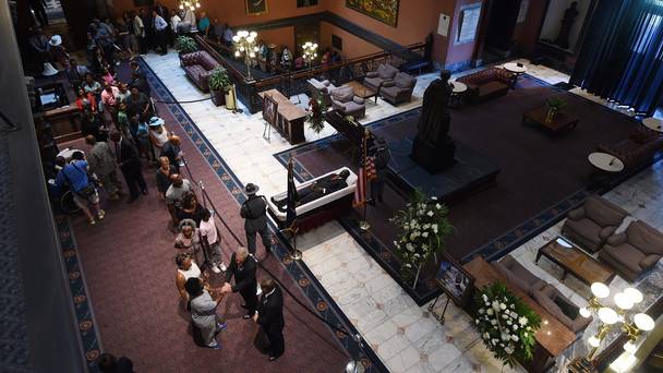 South Carolina Highway Patrol honour guard stand over Senator Clementa Pinckneys body as members of the public file past in the Statehouse