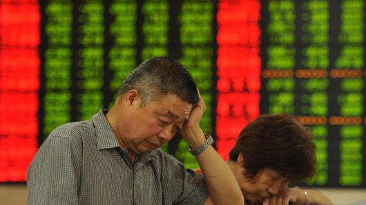 Investors observe the stock market at a stock exchange hall in Fuyang Anhui province of China