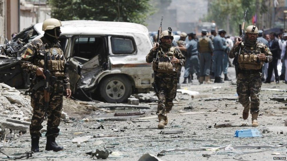 Afghan security forces run at the site of a suicide attack in Kabul on 7 July