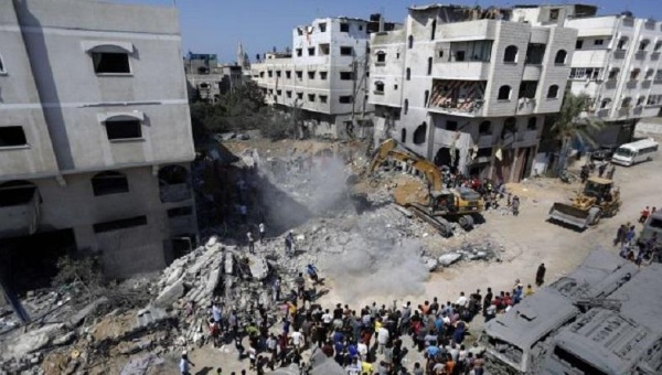 A digger removes debris of a home destroyed in an Israeli air strike on Gaza City