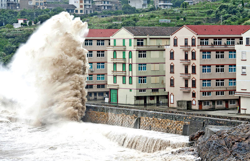 A wave under the influence of Typhoon Chan-hom hitting the shore next to residential buildings in Wenling Zhejiang province China on Saturday