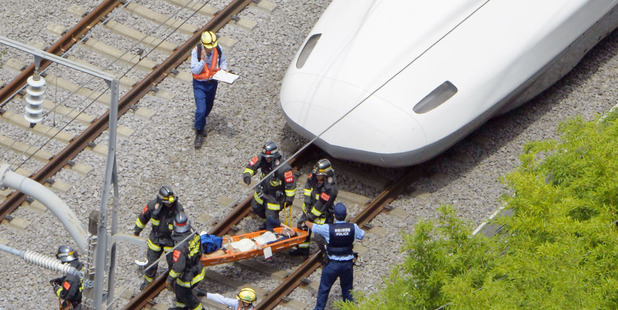 A passenger is carried out of the bullet train right which made an emergency stop in Odawara