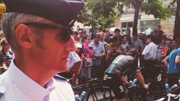 A police officer watches on as Team Sky riders prepare for the day