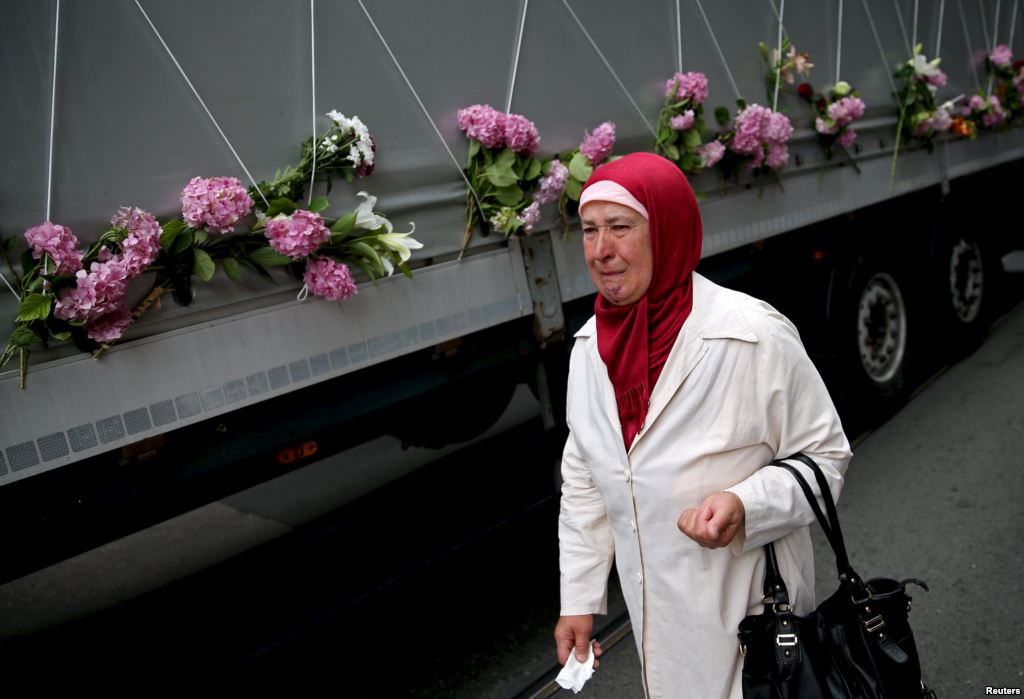 A woman cries near a truck carrying coffins of newly identified victims of the 1995 Srebrenica massacre in Sarajevo