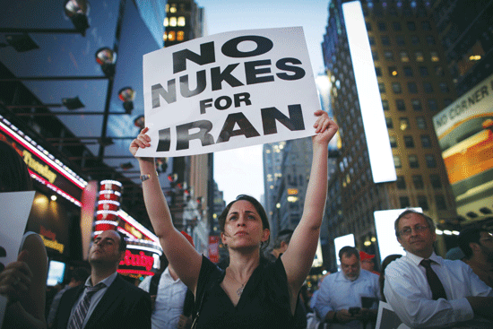 A woman holds a poster as she takes part in a rally late on Wednesday on Times Square in New York opposing the nuclear deal with Iran