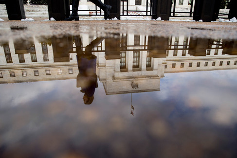 A woman walks past the Marriner S. Eccles Federal Reserve building in Washington D.C