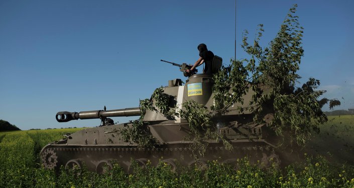 A Ukrainian serviceman rides atop an armored military vehicle to take their positions near Donetsk eastern Ukraine Sunday