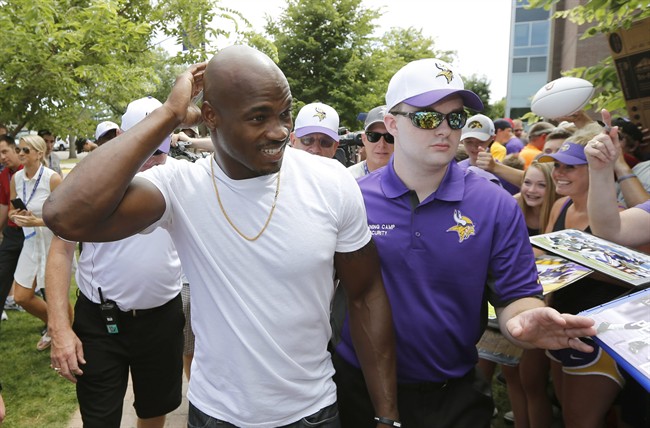 Minnesota Vikings running back Adrian Peterson smiles at fans as he reports to an NFL football training camp at Minnesota State University Saturday