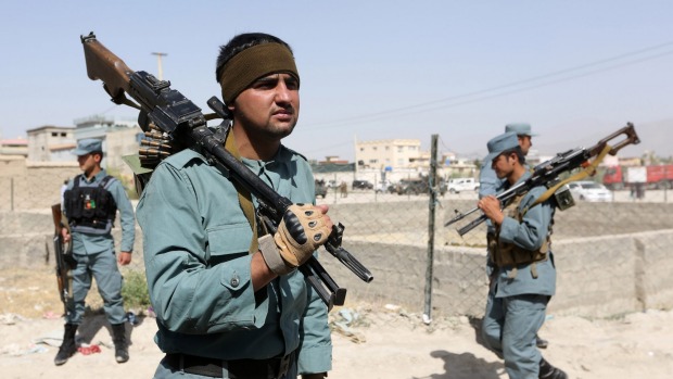 Afghan security forces inspect the site of a suicide attack after clashes with Taliban fighters at the gate of an intelligence facility in Kabul on Tuesday