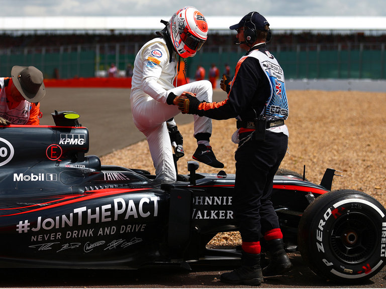 Button is helped from his Mc Laren after his first-lap retirement