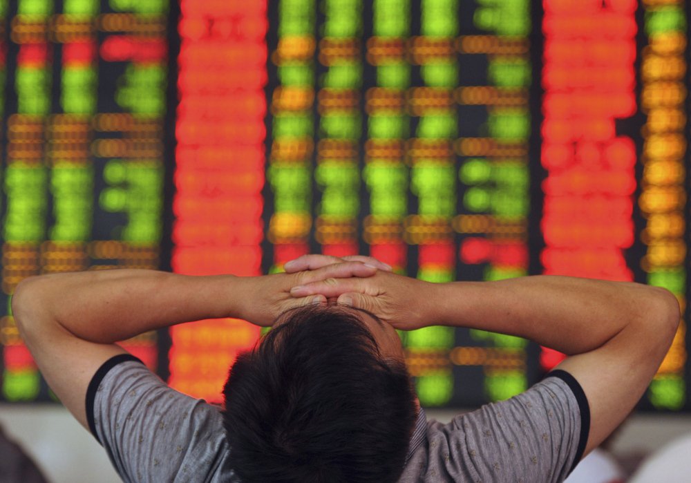 An investor covers his eyes at a brokerage house in Fuyang in central China’s Anhui province Wednesday