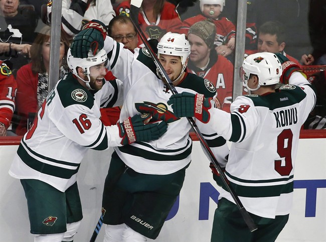 Minnesota Wild winger Jason Zucker celebrates with teammates Chris Stewart and Mikko Koivu a goal against the Chicago Blackhawks during the third period of an NHL hockey game Tuesday