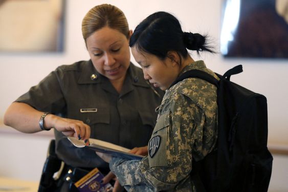 New York State Trooper Maxine Mendez left speaks to Xiaojiao Zuo of Queens about employment opportunities during a U.S. Chamber of Commerce Foundation Hiring Our Heroes jobs expo at Citi Field in New York. Th