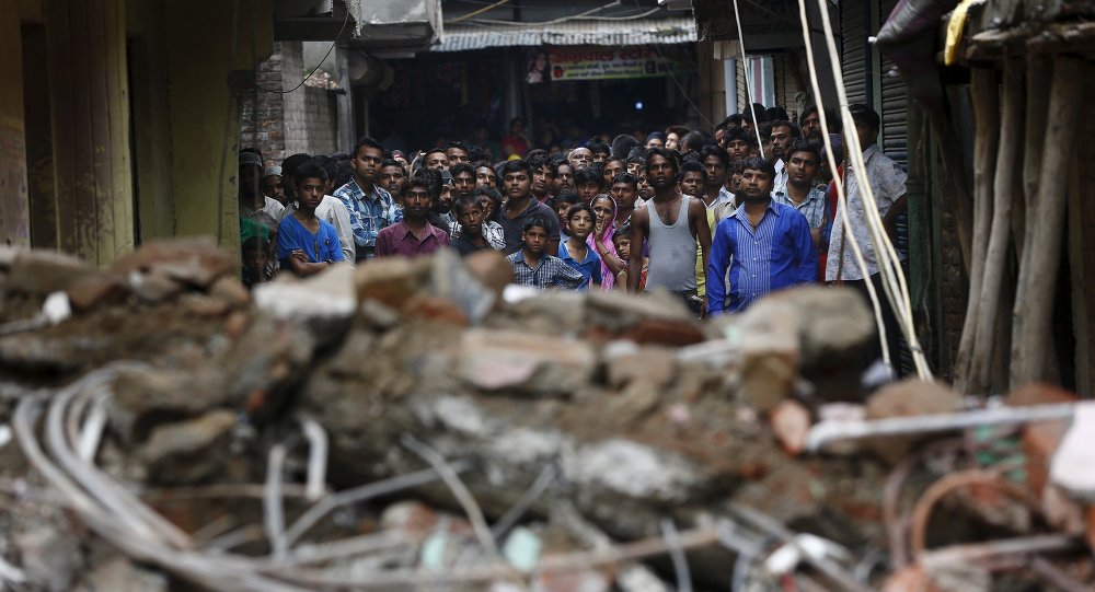 Onlookers stand at the site of a collapsed building