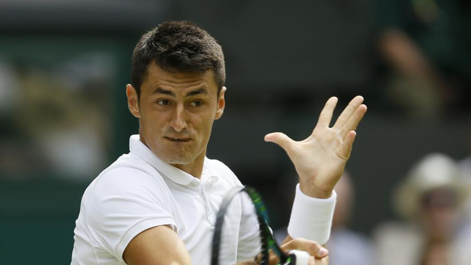 Bernard Tomic of Australia returns a ball to Novak Djokovic of Serbia during their singles match at the All England Lawn Tennis Championships in Wimbledon London Friday