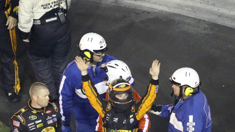 Austin Dillon center raises his arms to race fans to signify he was okay after he was involved in a multi-car crash in a NASCAR Sprint Cup series auto race at Daytona International Speedway Monday