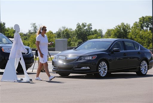 A pedestrian crosses in front of a vehicle as part of a demonstration at Mcity on its opening day Monday