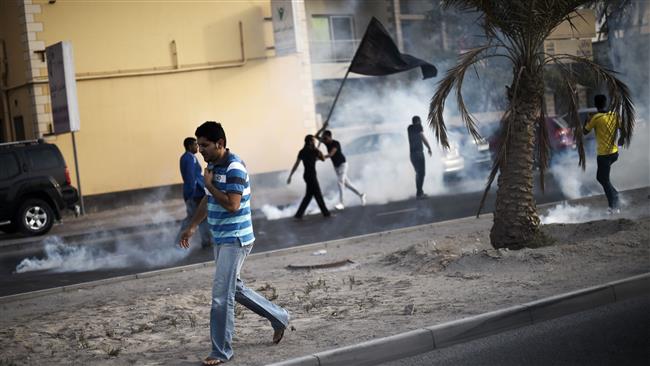 Bahraini protesters run for cover after police fires tear gas during clashes in the village of Jidhafs west of Manama