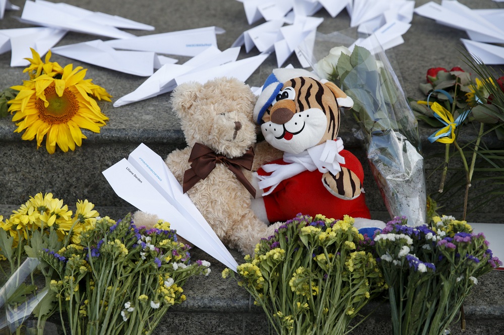 Flowers toys and self-made paper planes left to commemorate the victims of the Malaysia Airlines flight MH17 plane crash a year ago outside the Dutch embassy in Kiev Ukraine