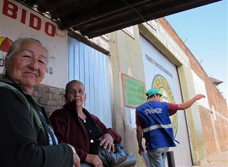 Angela Coimbra left the mother an inmate of the Palmasola prison waits outside the main gate with a friend as she attempts to deliver washing supplies to her son in Santa Cruz Bolivia Thursday