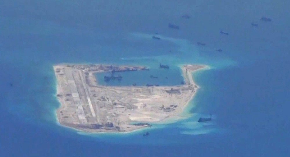 Chinese dredging vessels are purportedly seen in the waters around Fiery Cross Reef in the disputed Spratly Islands in the South China Sea in this still file image from video taken by a P-8A Poseidon surveillance aircraft provided by the United States Nav