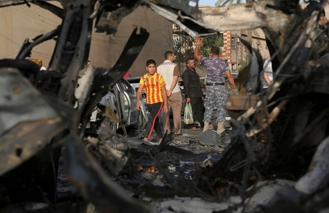 Civilians inspect the site of a car bomb attack on Palestine Street in eastern Baghdad Iraq Wednesday