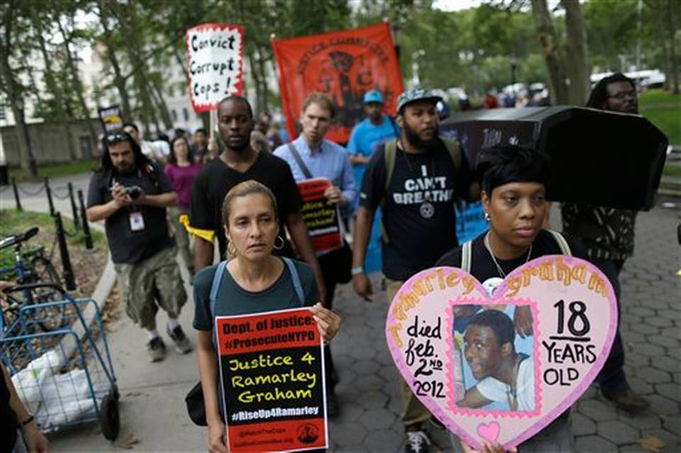 Constance Malcolm right the mother of Ramarley Grahamm leads a procession with symbolic coffins during a rally Saturday