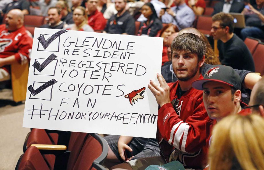 Arizona Coyotes fans Chris Webb second from right and Andrew Hill show their support for their team as the Glendale Council votes whether to back out of an arena lease agreement with the NHL team dur