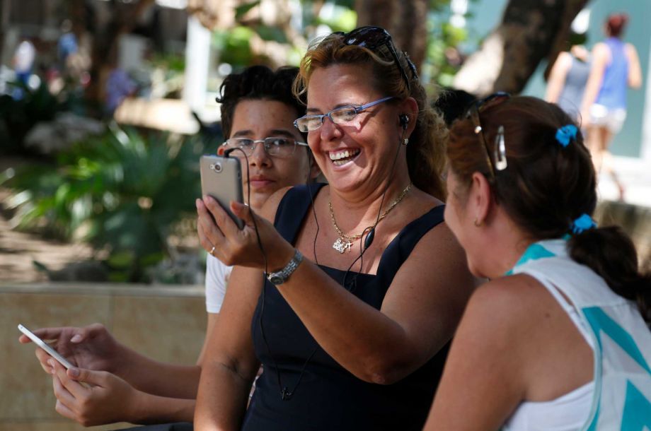 Flanked by her nephew Nelson Suarez left and friend Ana Maria Beltran Laura Martinez communicates with her son in Canada using the first public Wi Fi hotspot in Havana Cuba Thursday