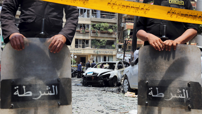 Policemen investigate the site of a car bomb attack on the convoy of Egyptian public prosecutor Hisham Barakat near his house at Heliopolis district in Cairo Egypt