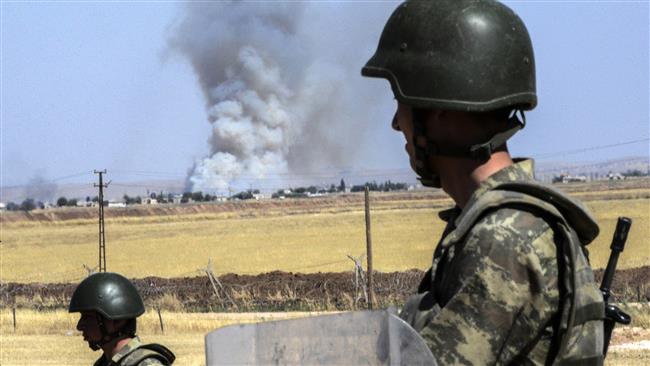 Turkish soldiers stand guard by the border with Syria on the way to Mursitpinar crossing gate in Suruc Sanliurfa province