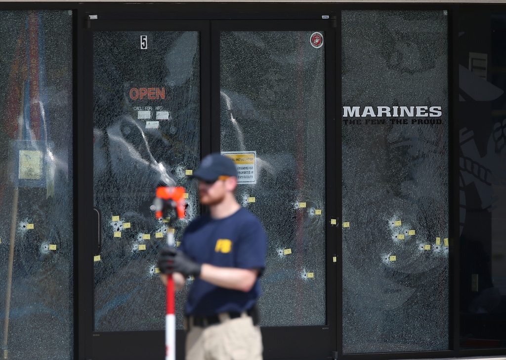 CHATTANOOGA TN- JULY 17 A member of the FBI Evidence Response Team works near the bullet riddled doors as he investigates the shooting at the Armed Forces Career Center  National Guard Recruitment Office