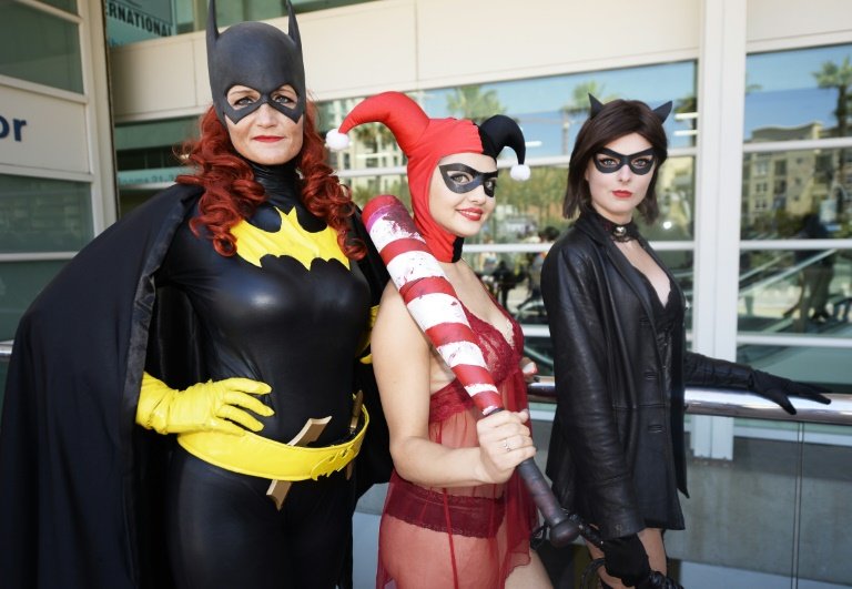 Attendees dressed as Batgirl Harley Quinn and Catwoman pose on the first day of Comic Con International in San Diego California