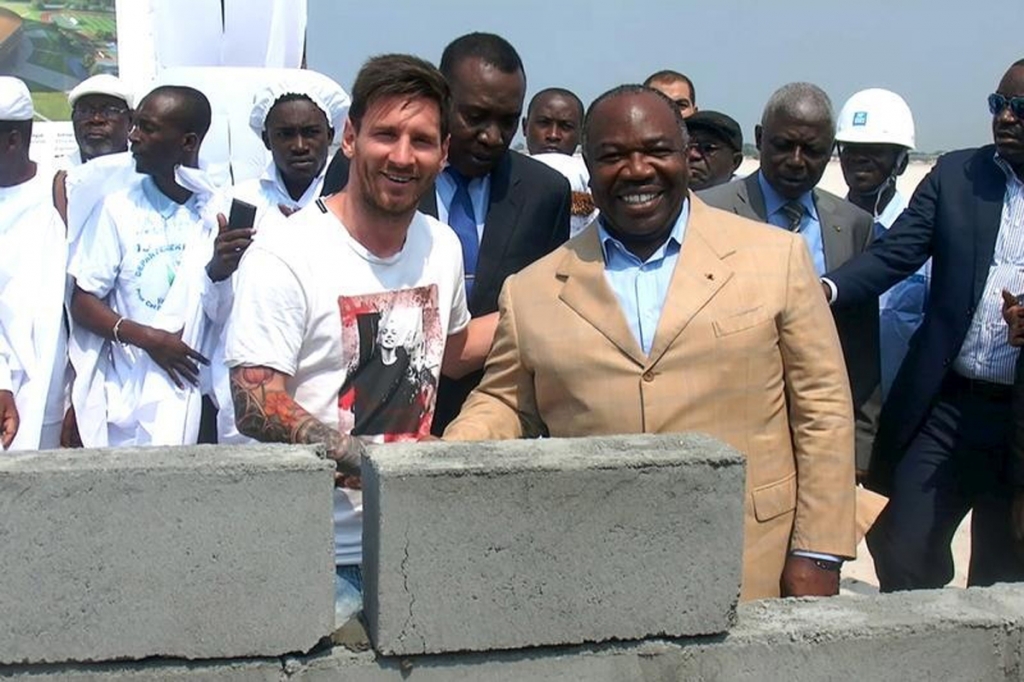 Gabonese President Ali Bongo Ondimba shakes hands with Lionel Messi