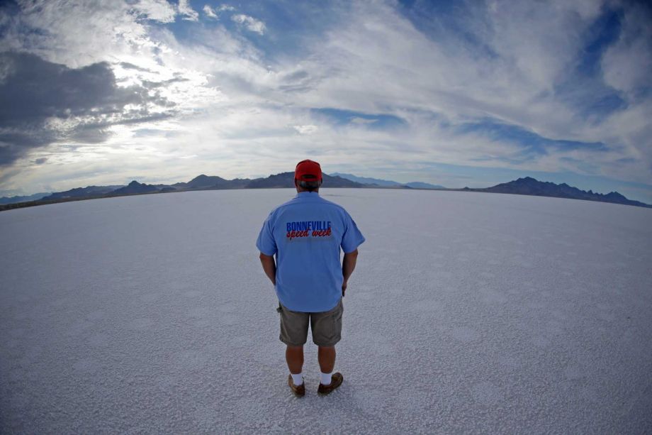 Bill Lattin the Southern California Timing Association president and Speed Week race director stands in the Bonneville Salt Flats in Utah. A small city of tents trailers and thousands of visitors appears almost ever