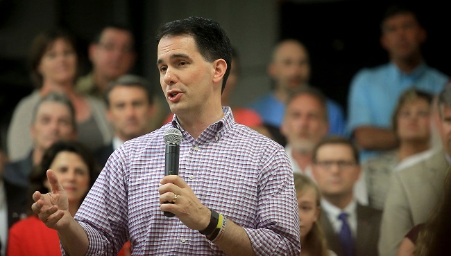 Wisconsin Gov. Scott Walker addresses employees and members of the media at Valveworks USA prior to signing the state's 2015-2017 budget on the production floor of the Waukesha Wis. company Sunday