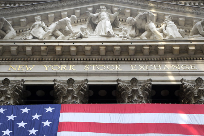 American flag is draped on the exterior of the New York Stock Exchange. Chinese stocks fell Tuesday July 7 despite government intervention and other global markets were mixed as Greece's spiraling crisis kept investors