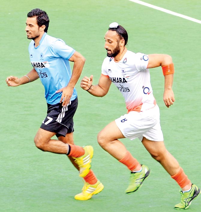 India captain Sardar Singh warms up with his teammate Gurbaj Singh during a training session. Pic  AFP