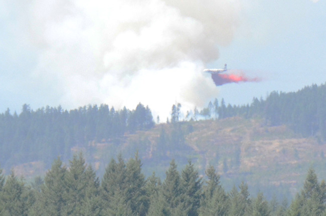 A bomber attacks the fire west of Campbell River with fire retardant. According to the Coastal Fire Centre eight firefighters are on the ground and two helicopters are helping the tanker group battle the fire.- Mike Davies  Campbell River Mirror