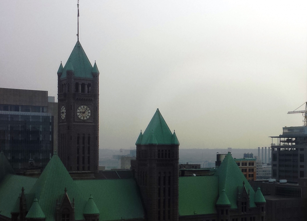 Looking past the rooftop of City Hall from downtown Minneapolis a haze caused by Canadian wildfires hugs the trees and rooftops of the surrounding community