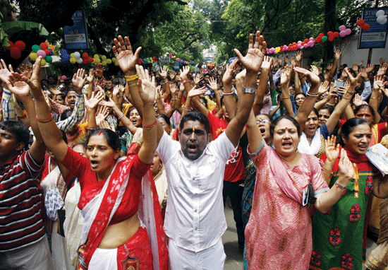 Hindu devotees raise their hands and shout religious slogans during the annual Rath Yatra or chariot procession in Kolkata yesterday