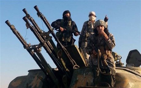 ISIS fighters on top of a military vehicle with anti-aircraft guns