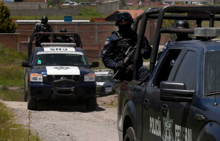 Federal Police stand guard near a half-built house near the Altiplano maximum security prison in Almoloya west of Mexico City Monday