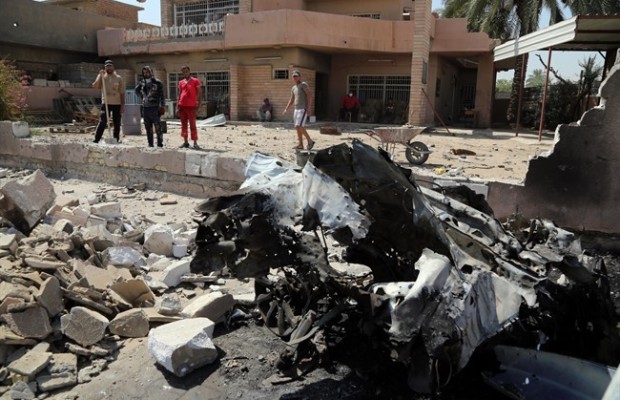 Iraqis clear up the aftermath the day after a car explosion in Baghdad which suffered a string of bombings including two suicide attacks that killed 29